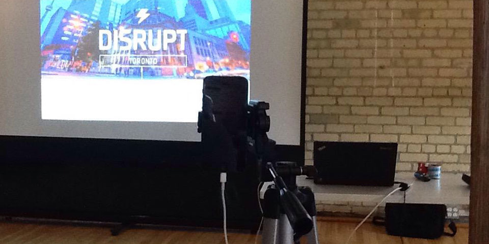 A photo of my tripod and iPhone set up in front of a slideshow screen